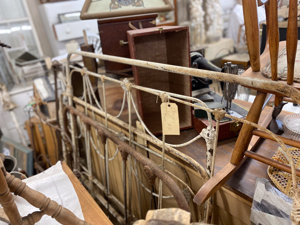 Antique brass and wooden bed frames at Junque Decor Floral and Greenhouse